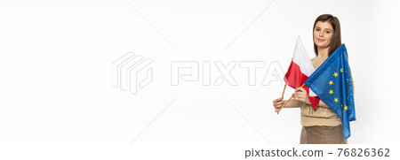 Young girl with the flag of the European Union and Poland. The student is holding two flags in her hand. Woman with flags on white background. Panoramic frame. Young girl with the flag of the European Union and Poland. The student is holding two flags in her hand. Woman with flags on white background. Panoramic frame. 76826362