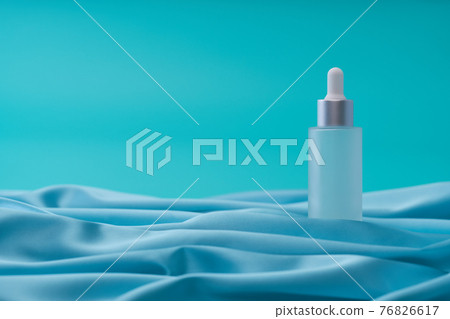 medical skin care, bottle for serum, micellar toner on blue background,selective focus. medical skin care, bottle for serum, micellar toner on blue background,selective focus. 76826617