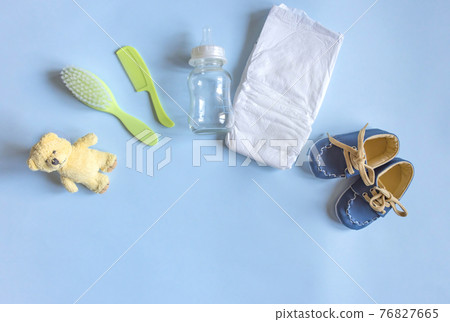 Baby care accessories, newborn baby diaper, comb and hair brush, bottle, little boy shoes and toy on a blue background. Wish list or shopping overview for pregnancy, baby shower concept. Baby care accessories, newborn baby diaper, comb and hair brush, bottle, little boy shoes and toy on a blue background. Wish list or shopping overview for pregnancy, baby shower concept. 76827665