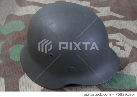 German Nazi Army steel helmet World War II period (1933-1945) on camouflaged background 76829180