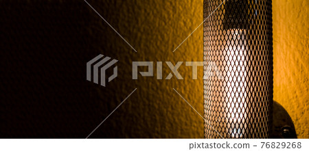 loft style wall lamp lattice pipe with edison light bulb on the facade of a building with yellow plaster close-up of architectural lighting. loft style wall lamp lattice pipe with edison light bulb on the facade of a building with yellow plaster close-up of architectural lighting. 76829268