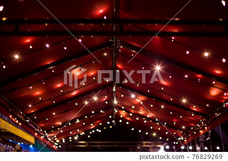 top of the canopy in a red textile gazebo with string light garlands decorative holiday lighting roof terrace night scene. 76829269
