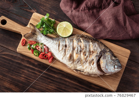 Grilled fish on the wooden board 76829467
