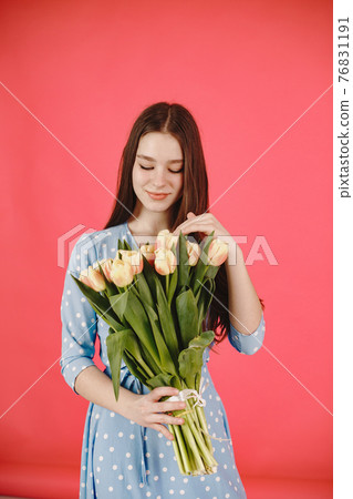 Girl with flowers on a red background Girl with flowers on a red background 76831191