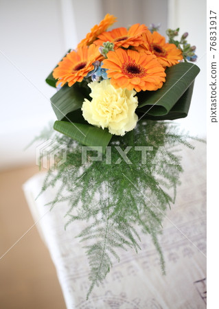 A bouquet of orange gerberas decorated in a bright room 76831917