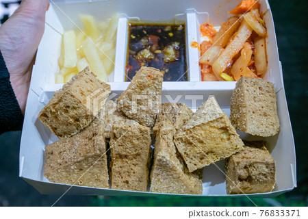 Stinky tofu, a close up of Taiwanese traditional deep fried beancurd street food at Taipei night market in Taiwan. 76833371