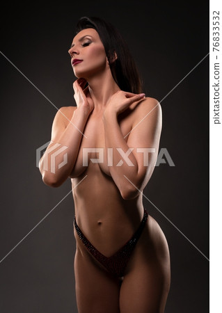 Topless woman touching neck with closed eyes 76833532