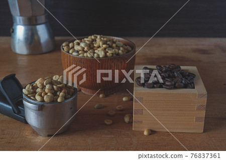 A pile of fresh coffee beans in bowl and wood box on wooden background. A pile of fresh coffee beans in bowl and wood box on wooden background. 76837361