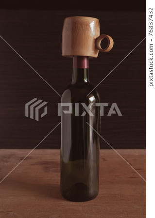 Bamboo cup with wine bottle on wood background. Bamboo cup with wine bottle on wood background. 76837432