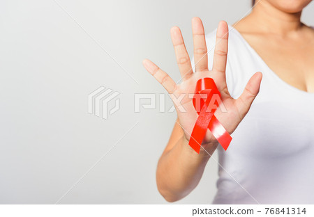 Closeup of female with red ribbon Support HIV AIDS on hand Closeup of female with red ribbon Support HIV AIDS on hand 76841314
