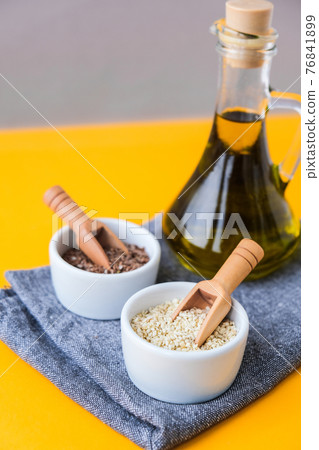 Sesame and flax seeds wooden spoons with oil in glass bottle. Healthy food concept. Vegan keto diet. Linseed oil. Sesame oil Minimalistic concept in isometric style in trendy colors. 76841899