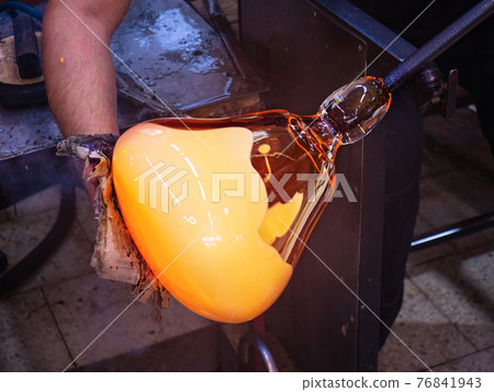 Art and craft worker shaping glass with mould from wet newspaper. 76841943