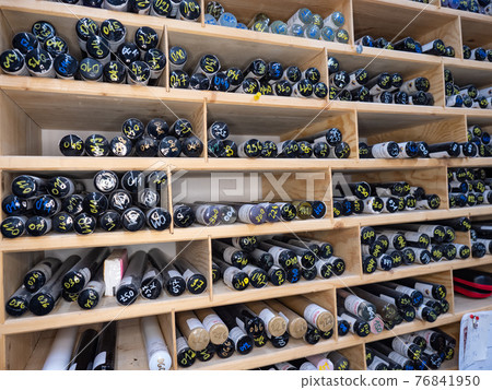 Glass pressing rods. Stack of bunch of colorful glass rods on shelf Glass pressing rods. Stack of bunch of colorful glass rods on shelf 76841950