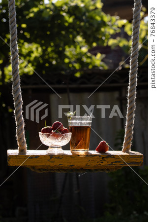 Cup of tea and wild strawberries on a wooden background Cup of tea and wild strawberries on a wooden background 76843379