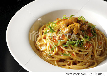 Sea urchin cream sauce pasta with raw sea urchin and salmon roe on a black background 76843853