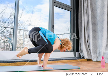 Sportive woman hold body on hands indoors Sportive woman hold body on hands indoors 76844546