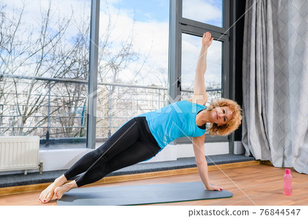 Middle age woman exercise with side plank Middle age woman exercise with side plank 76844547