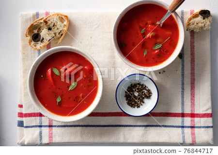 Tomato soup in a white bowl on white background. Top view. Copy space Tomato soup in a white bowl on white background. Top view. Copy space 76844717
