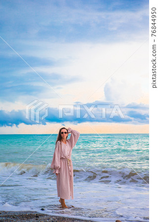 Woman on the beach enjoying summer holidays 76844950