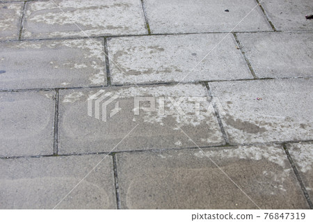 Concrete walkway with water patch 76847319