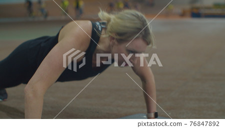 Athletic beautiful woman does push-ups as part of her cross fitness, bodybuilding gym training routine. Athletic beautiful woman does push-ups as part of her cross fitness, bodybuilding gym training routine. 76847892