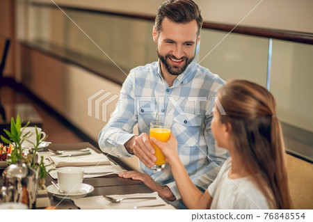 Kids and their dad sitting at the table in the restaurant 76848554