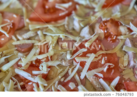Fragment of raw pizza with tomatoes, cheese and olives, background and texture 76848793