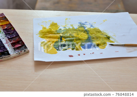 Children drawing with watercolors lies on the table, colored spots on a paper Children drawing with watercolors lies on the table, colored spots on a paper 76848814
