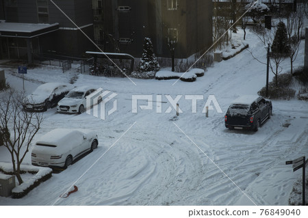 Snow-covered apartment ground-level parking lot Snow-covered apartment ground-level parking lot 76849040