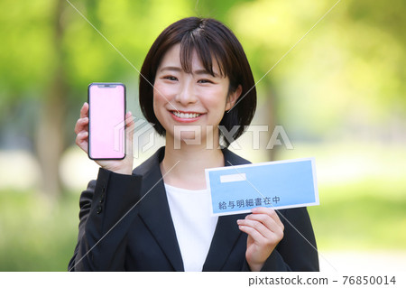 Woman with smartphone and pay slip 76850014