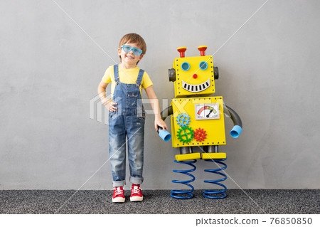 Happy child playing with toy paper robot 76850850