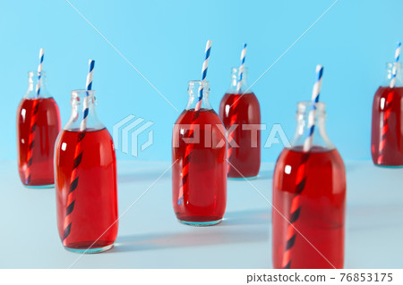 Set of summer iced cranberrie punch cocktails in bottles on blue background Set of summer iced cranberrie punch cocktails in bottles on blue background 76853175