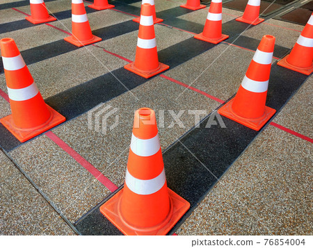 Traffic plastic cones are used instead of standing in order to society distance. Traffic plastic cones are used instead of standing in order to society distance. 76854004
