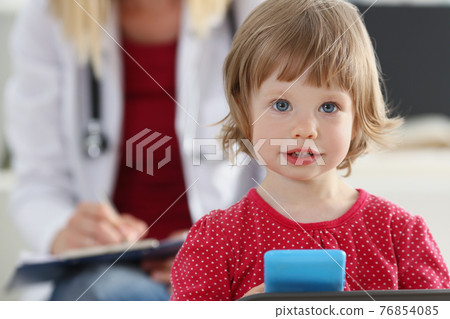 Portrait of little girl on background of doctor in white coat. 76854085