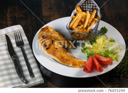 Roasted dinner on white plate containing chicken and potato, homemade fries 76855294