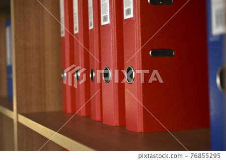 Office red folders on the shelf in the office 76855295