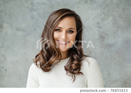 Casual woman brunette smiling on gray background, portrait 76855815