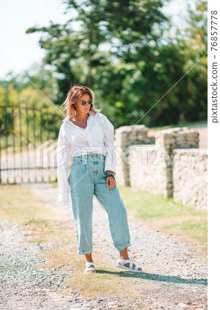 Portrait of young attractive tourist woman outdoors 76857778