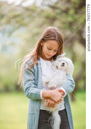 Little smiling girl playing in the park 76857779