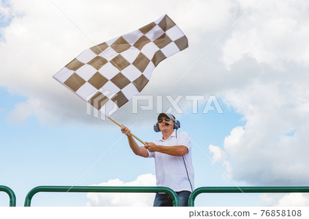 Man waves a checkered flag 76858108