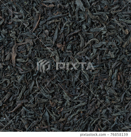 View from above. Large leaf tea background. Natural structure of dried tea leaves. Black tea. Close-up View from above. Large leaf tea background. Natural structure of dried tea leaves. Black tea. Close-up 76858139