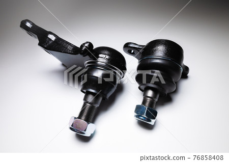 A set of two ball joints of the front suspension of a passenger car on a gray background. Service and new parts A set of two ball joints of the front suspension of a passenger car on a gray background. Service and new parts 76858408