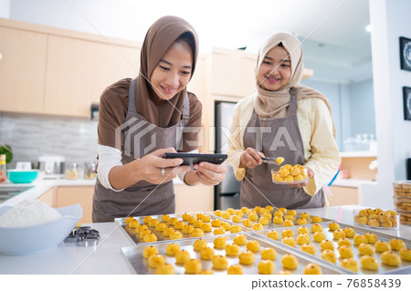 muslim woman taking picture of the food product they made at home muslim woman taking picture of the food product they made at home 76858439