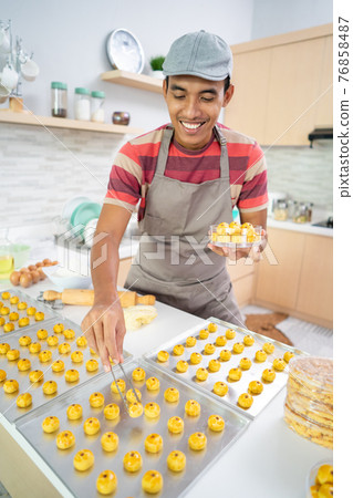 man put nastar cake on a plastic container box man put nastar cake on a plastic container box 76858487
