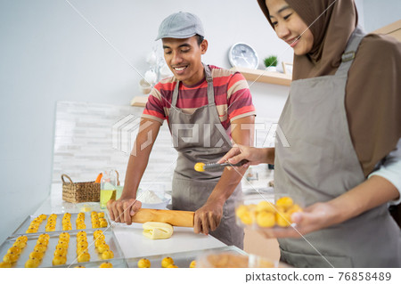 muslim couple making nastar snack cake together in the kitchen during ramadan muslim couple making nastar snack cake together in the kitchen during ramadan 76858489