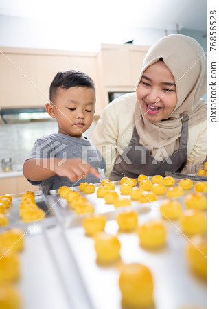 muslim mother making cake for eid mubarak with her son muslim mother making cake for eid mubarak with her son 76858528