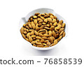 A group of shelled almonds in a white bowl. Perfect shot for breakfast, vegan, health and wellness. 76858539