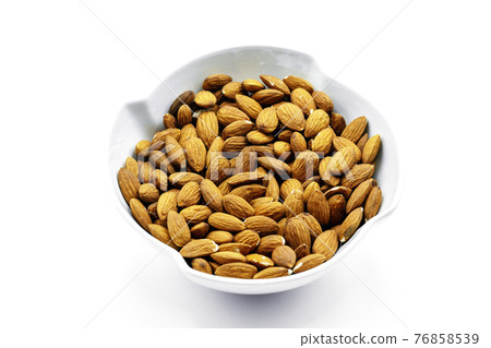 A group of shelled almonds in a white bowl. Perfect shot for breakfast, vegan, health and wellness. 76858539