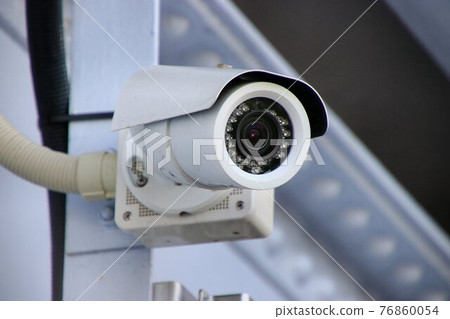 Security camera watching over the city Security camera watching over the city 76860054