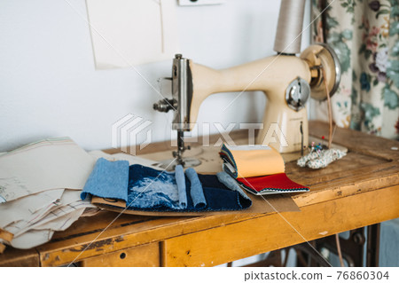 Supporting local, Tailoring small business. Seamstress, dressmaker, designer retro style workplace. Sewing machine with fabric samples, Threads and needles. Supporting local, Tailoring small business. Seamstress, dressmaker, designer retro style workplace. Sewing machine with fabric samples, Threads and needles. 76860304